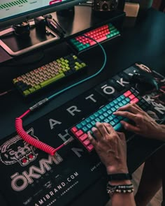 a person is typing on a keyboard in front of a computer monitor and other electronic equipment