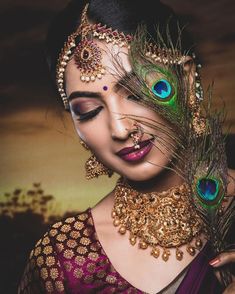 a woman with peacock feathers on her head and makeup is posing for a photo in front of the camera