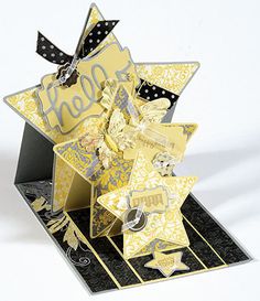 a star shaped card with the word hello written in silver and gold on it's side