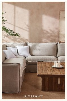 a living room with a couch and coffee table in front of a painting on the wall