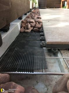 there are some rocks laying on the ground next to each other in front of a metal grate