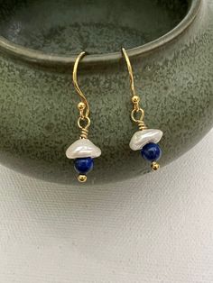 Snowy white keshi pearls are paired with royal blue lapis lazuli and finished with gold-filled findings to make a beautiful pair of earrings. Small and lightweight and perfect for those who love things light and easy, but rich in color. Pearl is the birthstone for June. As with all of my items, your purchase will come in an organza bag with a gift tag so it's ready to give upon arrival. The earrings shown are representative of the well-matched pair you will receive. As with the humans who wear t Blue Pearl Charm Drop Earrings, Blue Pearl Earrings With Pearl Charm, Blue Drop Pearl Earrings With Pearl Charm, Blue Pearl Charm Earrings As Gift, Handmade Blue Pearl Earrings, Keshi Pearl Earrings, Earrings Boho Chic, Small Dangle Earrings, Petite Earrings