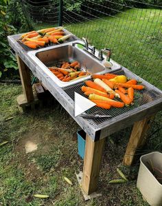 there are carrots being cooked on the grill in the yard by the water trough