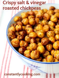 crispy salt and vinegar roasted chickpeas in a blue bowl on a striped napkin