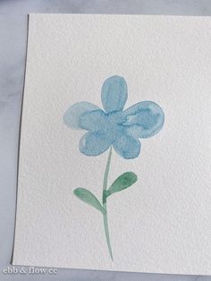 a watercolor painting of a blue flower on white paper