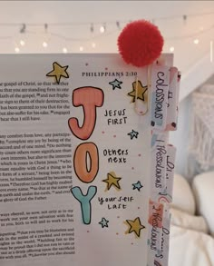 a book with the word joy written on it and a red pom - pom