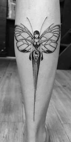 a black and white photo of a woman's leg with a butterfly tattoo on it