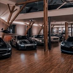 there are many cars in the garage on this wood floored area with exposed ceilings