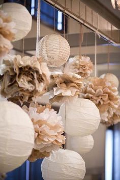 paper lanterns are hanging from the ceiling with flowers on them, and they look like they have been made out of tissue