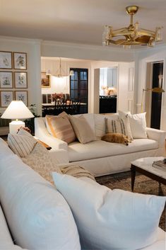 a living room filled with white couches and pillows