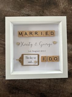 a wooden scrabble frame with the words married and i do written on it