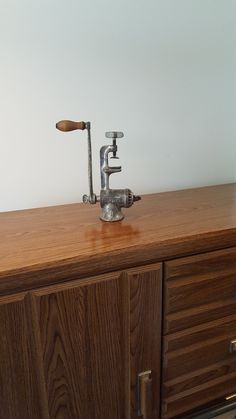 a faucet sitting on top of a wooden dresser