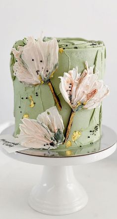 a green cake with white flowers on it