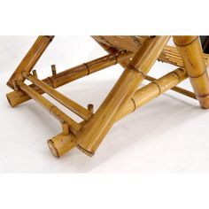 a bamboo stool with two legs and one foot on the seat is made out of wood