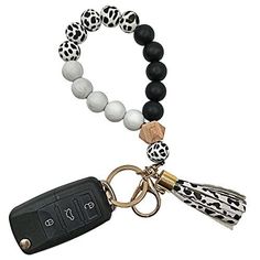 a black and white beaded bracelet with a car keychain attached to it