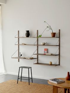 a living room filled with furniture next to a wall mounted planter and bookshelf