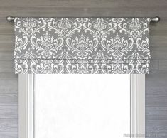 a window with a gray and white roman blind