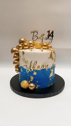 a white and blue cake with gold decorations