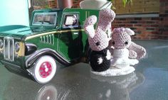 two crocheted stuffed animals sitting on top of a table next to a toy truck