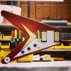 a red and white guitar sitting on top of a table