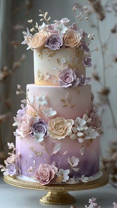 a multi - tiered cake with flowers on it is sitting on a gold plate