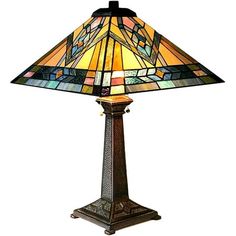 a lamp that is sitting on top of a wooden stand with a stained glass shade