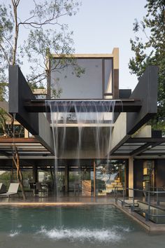 a house with a waterfall coming out of it's front door and into the back yard