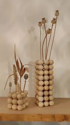 two vases with flowers and rocks on a table