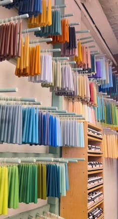 the colorful umbrellas are hanging on the wall in the store's display area