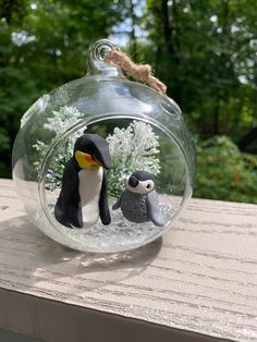 two penguins in a glass ornament on a table