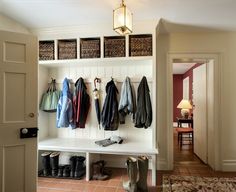 a coat rack with umbrellas and boots hanging from it's hooks on the wall