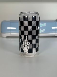 a glass with a checkered design on it sitting next to a blue and white object