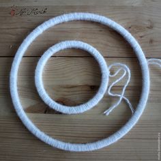 a piece of white yarn sitting on top of a wooden floor