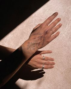 a woman's hand with tattoos on her left arm and the other half of her wrist