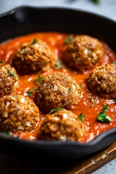 meatballs in tomato sauce and parmesan cheese on a cutting board with herbs