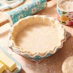 an uncooked pie sitting on top of a table next to other baking supplies