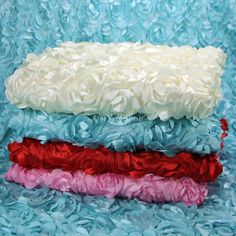 three different colors of flowered fabric on a blue cloth with red, white and pink flowers