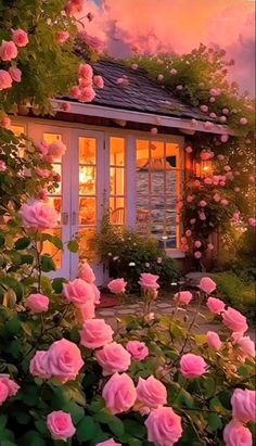 pink roses are blooming in front of a small house at dusk with the moon shining