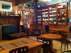 the inside of a library with tables and chairs in front of shelves full of books