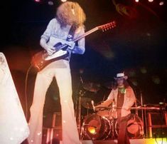 two men on stage with guitars and drums