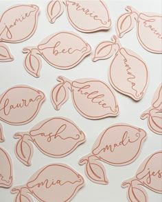 some pink stickers that are on top of a white surface with words and leaves