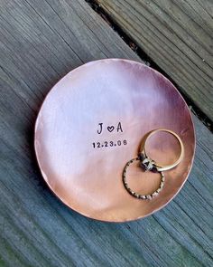 a personalized copper plate with two wedding rings on it