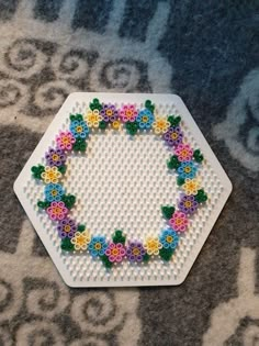 a white plate with flowers on it sitting on top of a carpeted floor next to a rug