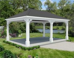 a white and blue gazebo sitting on top of a lush green field