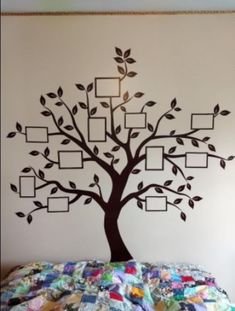 a family tree wall decal on the side of a bed with four frames attached to it