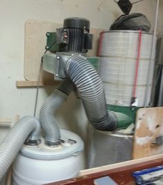 a white toilet sitting inside of a bathroom next to a metal trash can on top of a wooden shelf