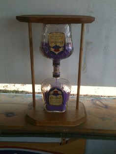 two glass bottles sitting on top of a wooden stand