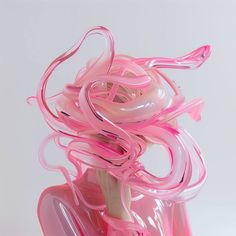 there is a pink sculpture made out of plastic tubes and ribbons on top of it