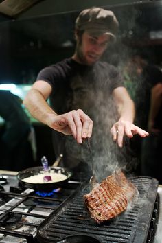 a man is grilling some meat on the grill