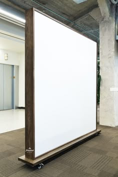 a large white board sitting in an empty room